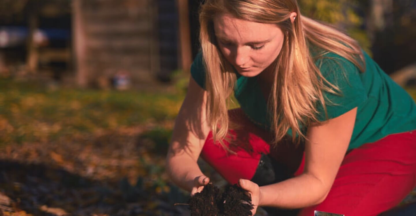 young woman examining soil